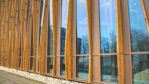 Photo of the side of a building made out of reclaimed wood | Featured image for the Sustainable Architecture Materials blog from Clements Clarke Architects.